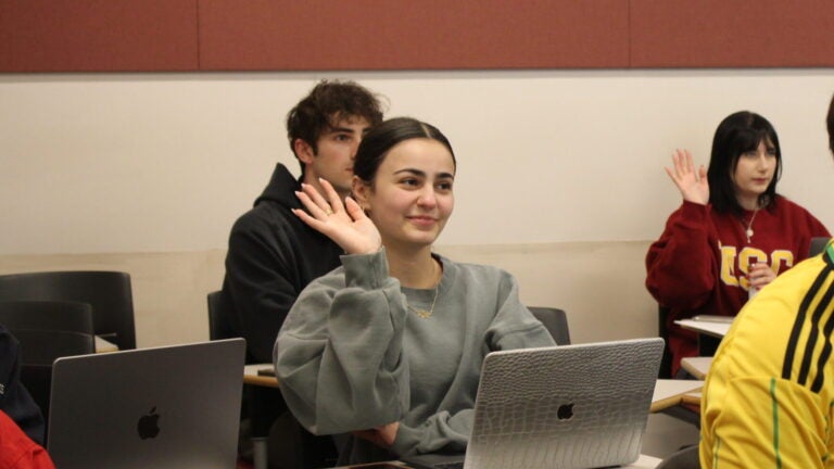 Student raising her hand in a classroom