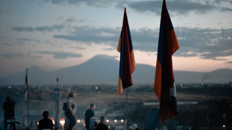 Yerablur Military Pantheon with the flags of Armenia and Artsakh in the foreground and Mount Ararat in the background