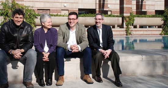 The Holocaust Geographies Collaborative sit on the edge of a fountain in front of Leavey Library.