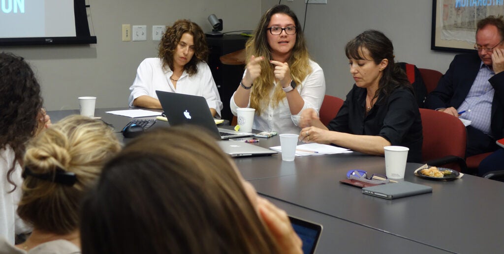 The 2017-2018 Latin American Research Week Team sit on either side of tables pushed together in a USC History building conference room. From left to right: Daniela Gleizer Salzman, Lorena Avila Jaimes, Nancy Nicholls Lopeandía, and Wolf Gruner. Various laptops, notes, cups, and food are scattered across the table.