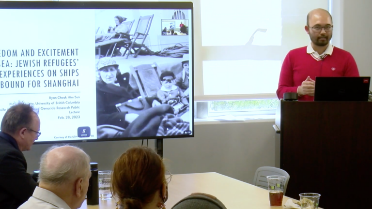 Screenshot of Ryan Sun presenting in a Taper Hall room. Ryan smiles with his hands clasped.