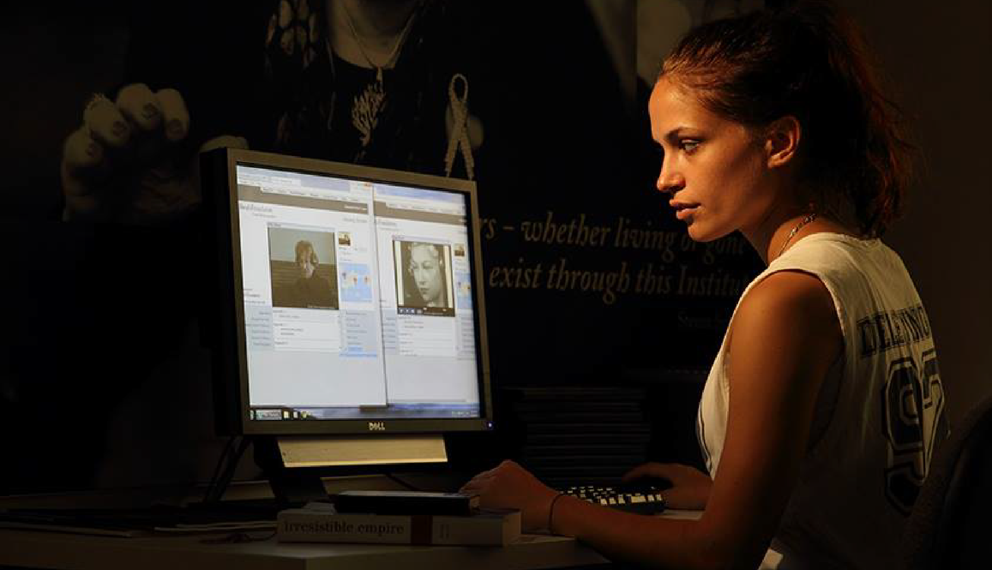 Photo of a white woman looking at the USC Shoah Foundation's Visual History Archive on a computer screen. The photo is dramatically lit.
