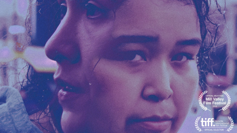 Cropped movie poster. Awash in purple and pink, two Indigenous women's faces are overlapped each another. One looks at the viewer.
