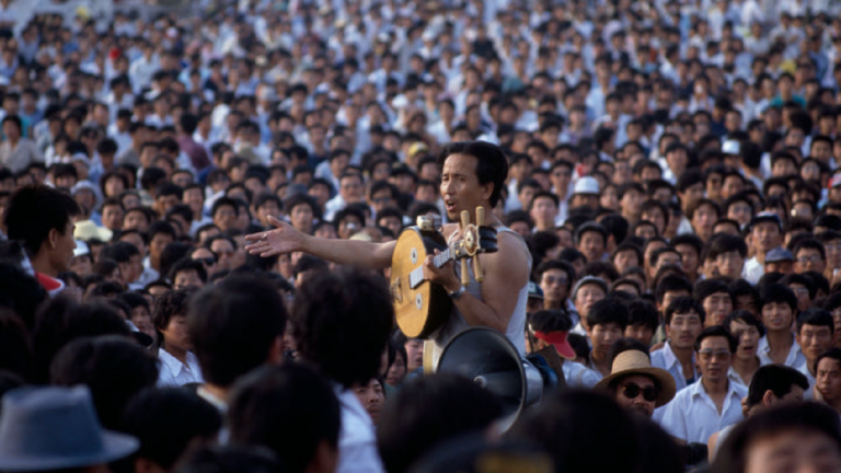 A Chinese man holds a zhongruan, a Chinese stringed instrument, amongst a crowd of student protesters. At Beijing’s Tiananmen Square protests in 1989, students played Beethoven’s Ninth over makeshift loudspeakers