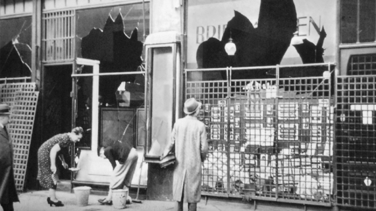 Historical photograph from Berlin, November 10th, 1938. Depicts the aftermath of the Kristallnacht. Store owners clean the pavement in front of shattered storefront windows.