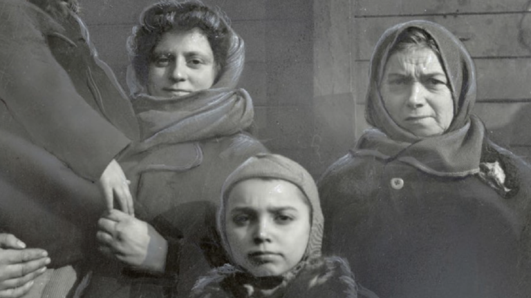 A 1946 black and white photo depicts three women posing in front of a railroad car. 