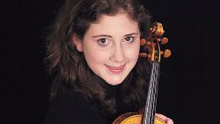 A portrait photo of Alexandra Birch. She holds a violin.