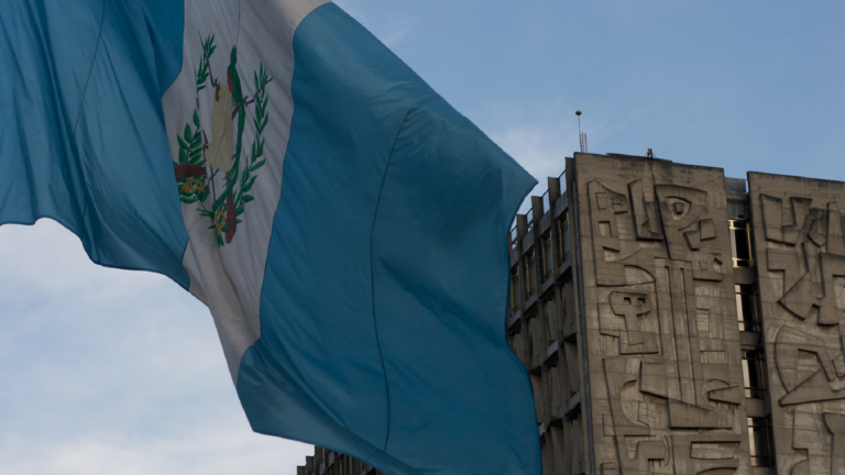The Guatemalan flag flies in front of Brutalist-style Bank of Guatemala.