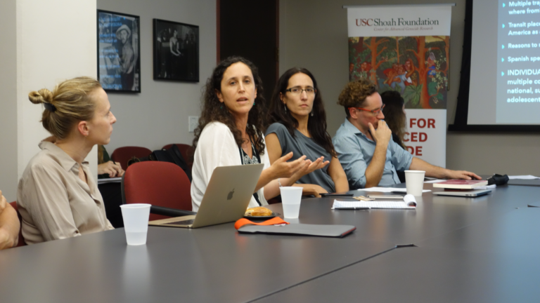 The 2017 to 2018 Latin American Research Week Team discuss their research with each other in a USC History building conference room. From left to right: Maria Zalewska, Yael Siman, Susana Sosenski, and Emmanuel Kahan. Various laptops, notes, cups, and food are scattered across the table.