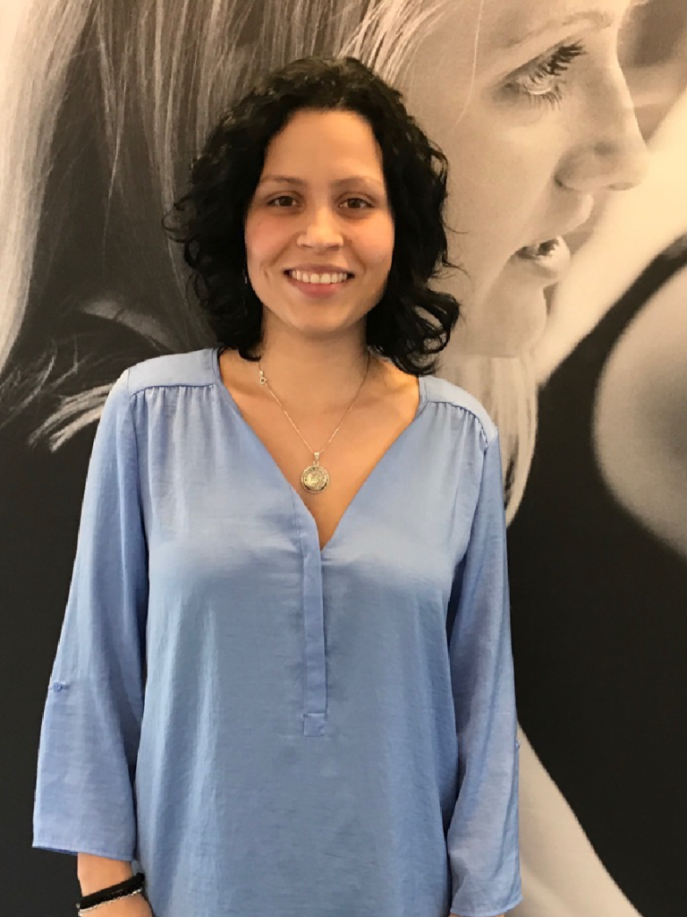 Vanessa Belén Dorda Meneses poses for a picture, smiling, in front of a black and white backdrop.
