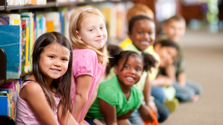 Children sitting in front of a bookshelf in a library