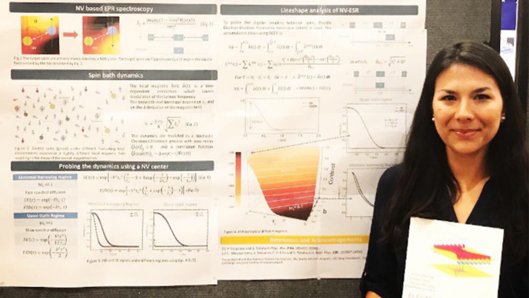 Woman holding document in front of a poster