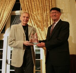 Two men holding an award
