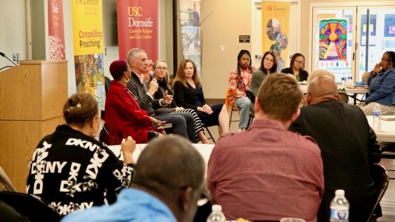 People on panel discuss with audience