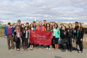 Students pose with a USC Dornsife flag in Reykjavik, Iceland.