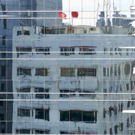 a high rise building seen reflected in the windows of another high-rise building