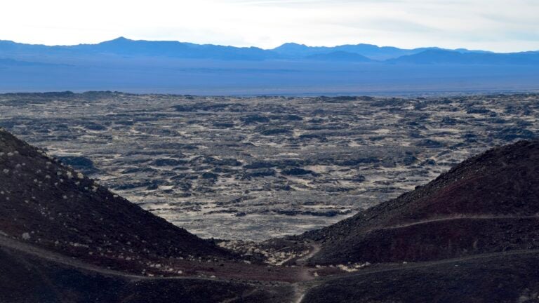 View of the Amboy basaltic lava field through the breached crater wall of the volcano