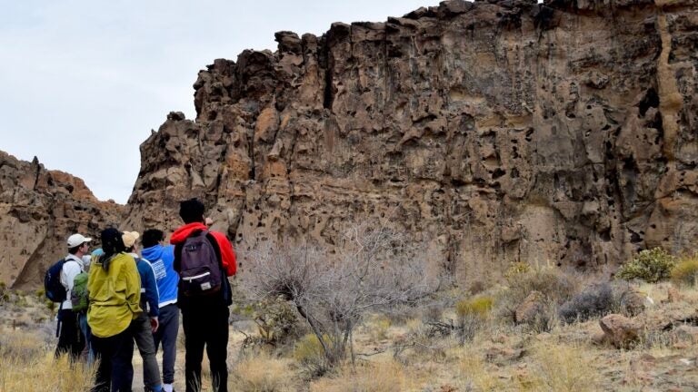 Class discussing an ignimbrite (fused volcanic ash) deposit formed from an explosive volcanic eruption