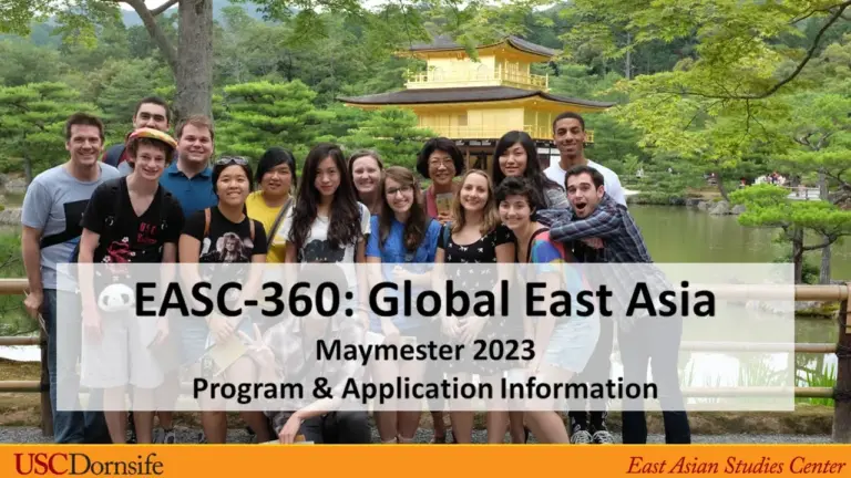 A group photo of multiple students in front of a Japanese garden.