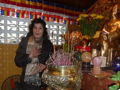 A woman in a room with various items, including crystal balls and incense.