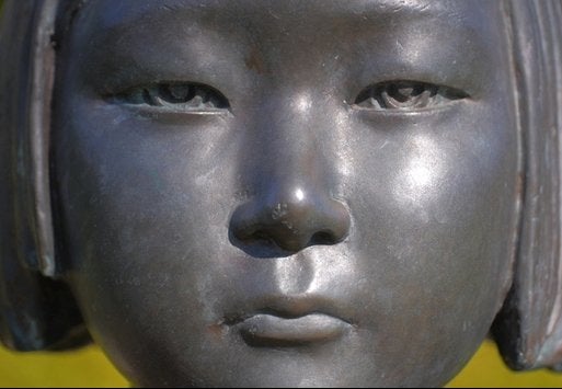 An extreme close-up of a statue of a young girl