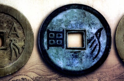 A blue Chinese Qing-dynasty coin. It's a coin with a square hole in the middle.