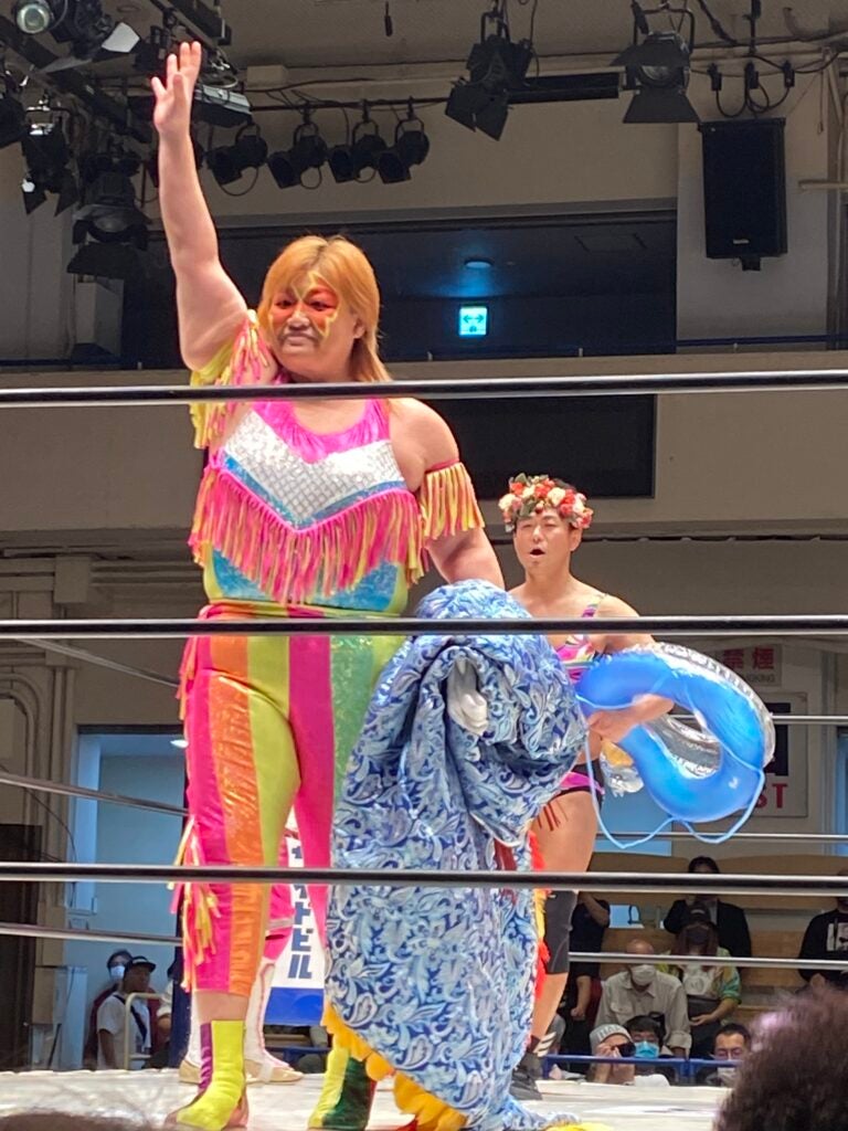 A female wrestler waving to the audience