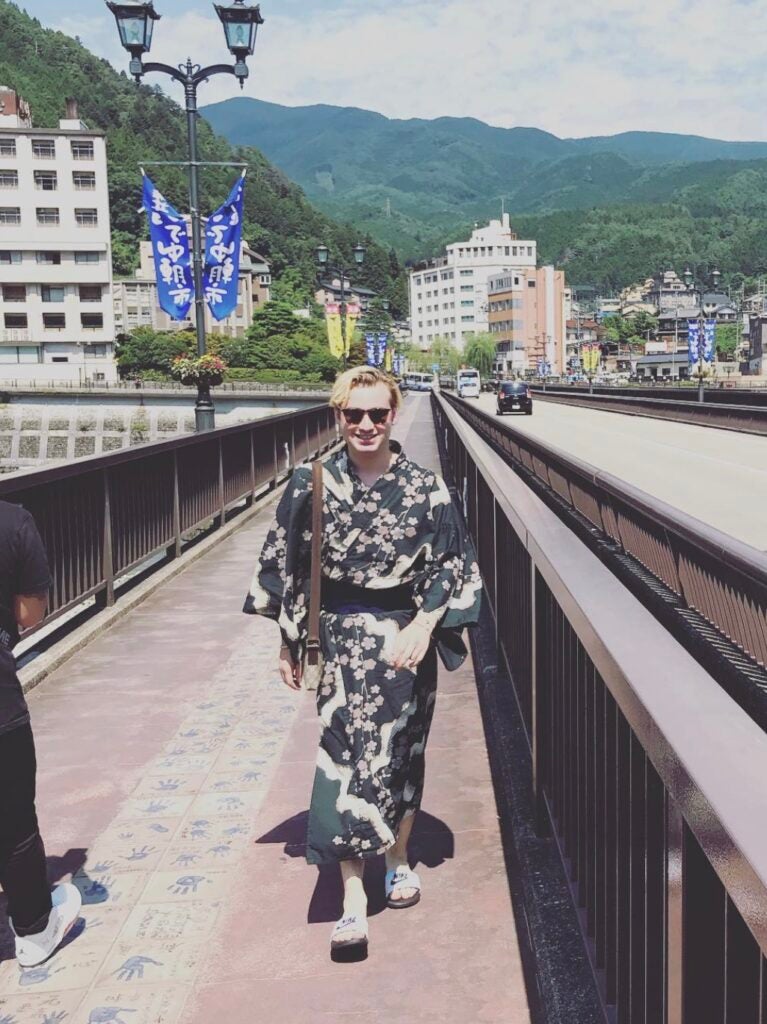 Kuper Bergman walking across a bridge in a kimono