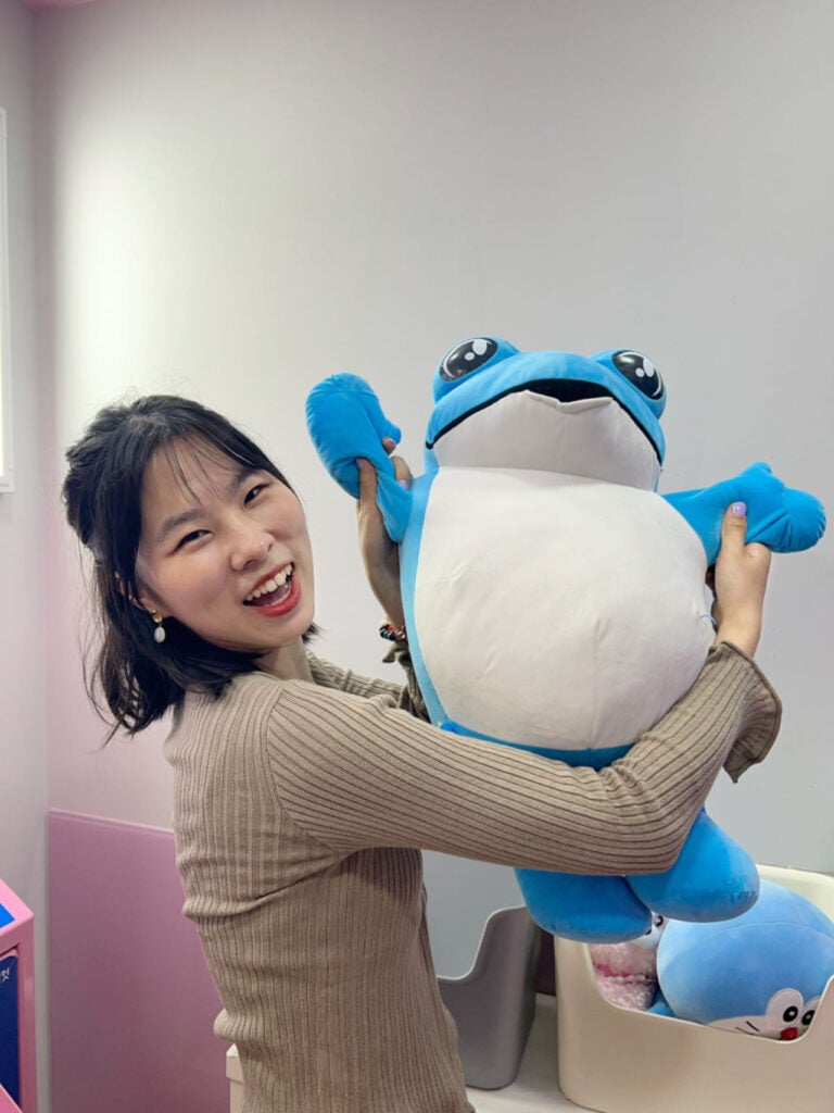Fiona with a large blue frog plush
