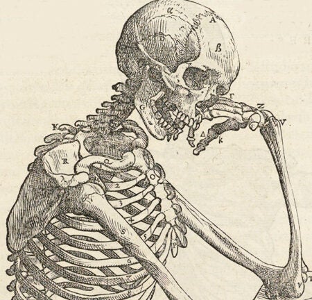 Skeleton with chin resting on hand.