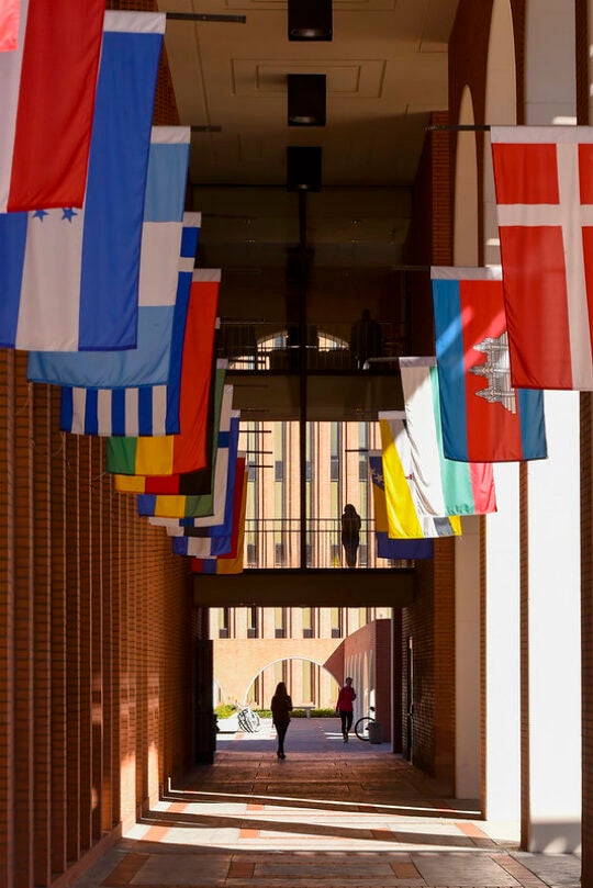 An individual walks down the USC hall of flags.