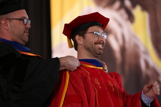 At commencement, a PhD student is hooded.