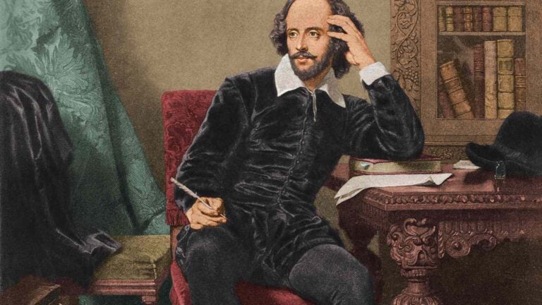 An illustrated depiction of Shakespeare shows the writer leaning against an antique desk with a pen in his right hand. His expression is thoughtful.
