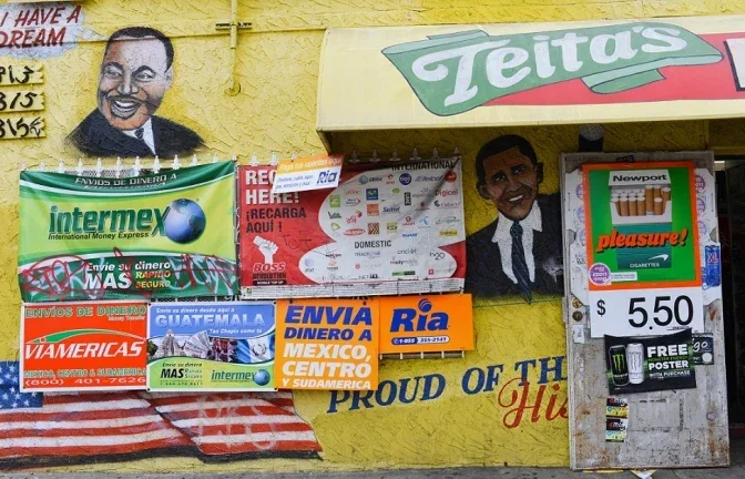 Store front covered with advertisements and art of Martin Luther King Jr and Barack Obama