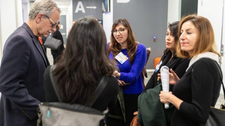 Dr. Manuel Pastor speaking with a group of event attendees