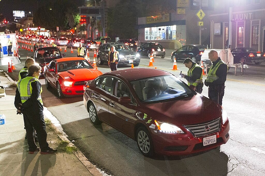 Police officers speak with drivers at a vehicle checkpoint