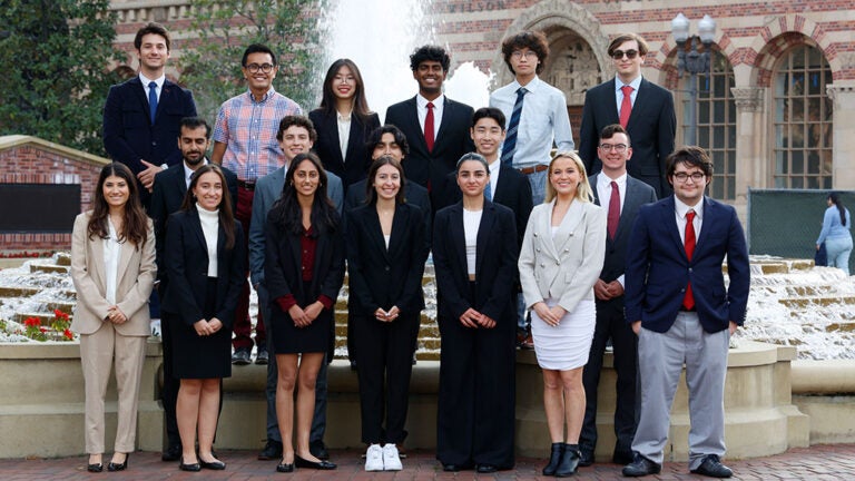 Southern California Moot Court team poses on campus in front of a fountain.