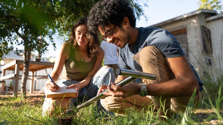 Students outside taking measurements of soil