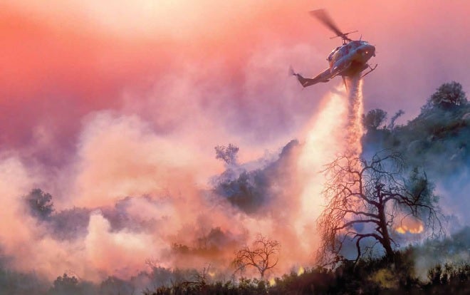 Photo of a helicopter helping to put out a wildfire.
