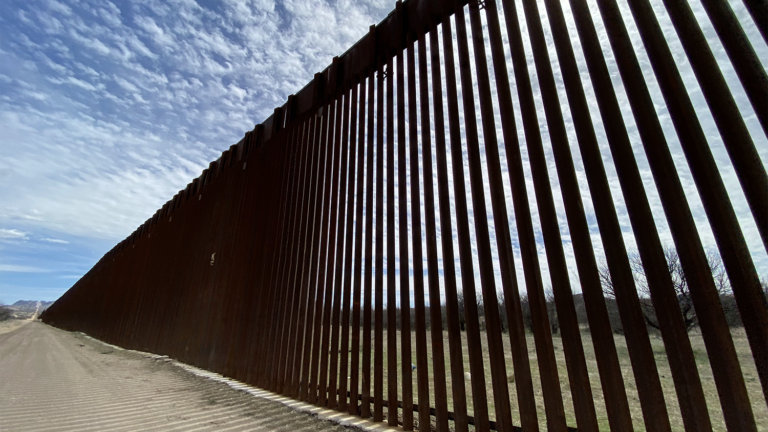 A photo of a tall steel wall along the border between the U.S. and Mexico