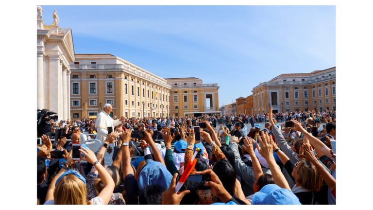 A photo of a crowd of people greeting Pope Francis