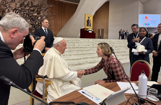 A photo of IACS Affiliated Scholar Tricia Bruce shaking hands with Pope Francis