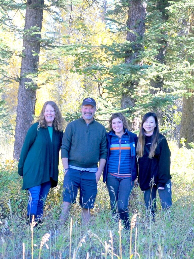 A photograph of the ICW team- Elizabeth Logan, Bill Deverell, Jessica Kim, and Stephanie Yi (left to right) in front of trees at Jackson Hole, Wyoming.
