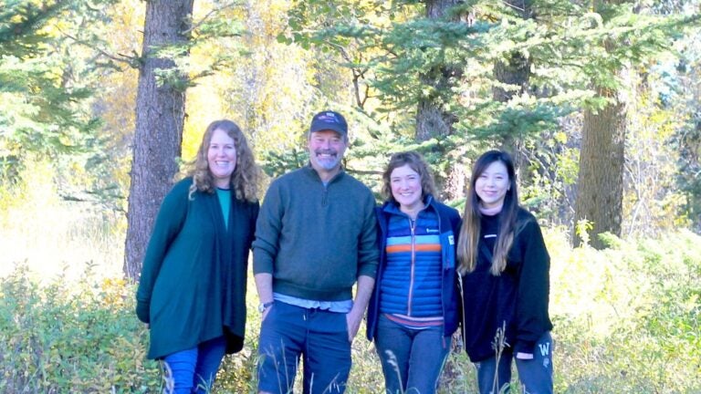 A photograph of the ICW team- Elizabeth Logan, Bill Deverell, Jessica Kim, and Stephanie Yi (left to right) in front of trees at Jackson Hole, Wyoming.
