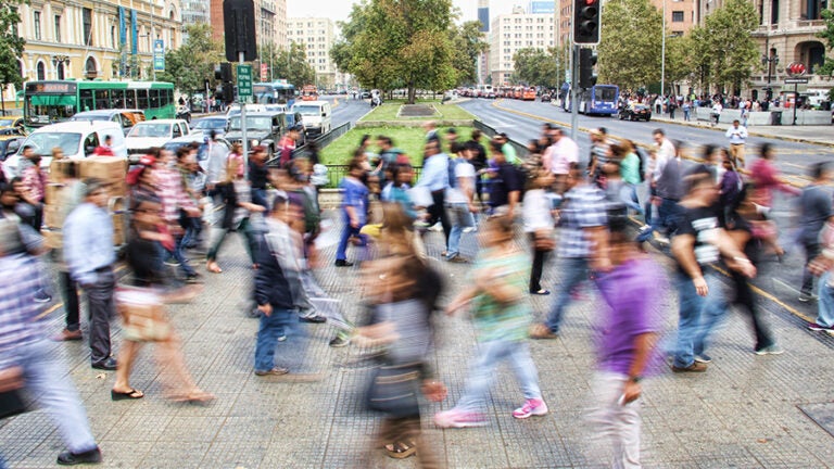 A crowd of people crossing the street in a city