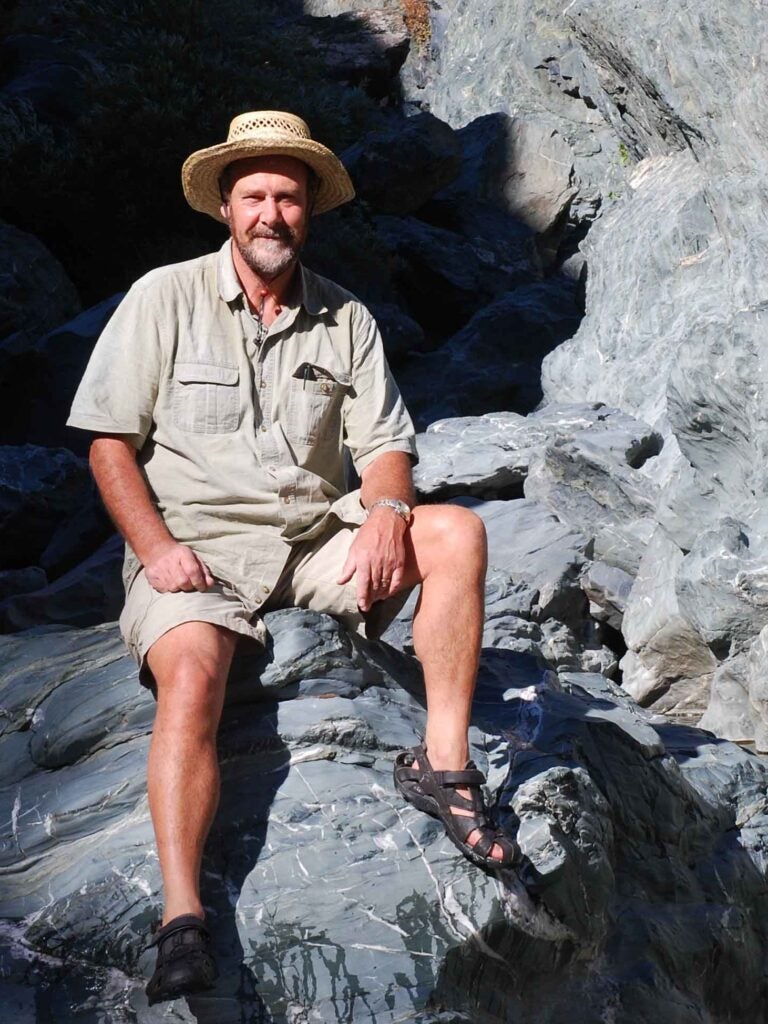 John Platt sitting on a rock.