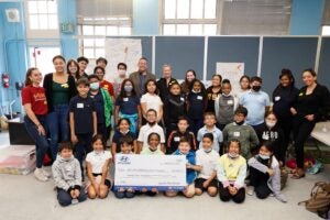 Group Photo of kids and facilitators and a big check being held