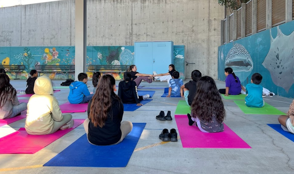 2 USC Students teaching Yoga to K-5 Students