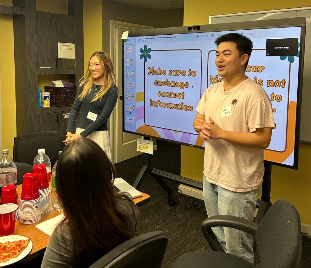 Christine and Marcus standing in front of a big screen