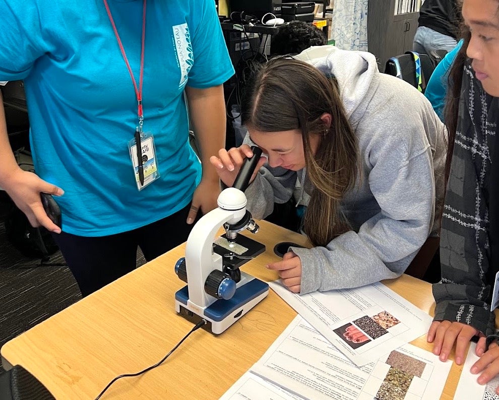 Student looking through microscope